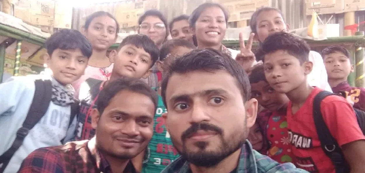 আইনুল হকে তেওঁৰ পুথিভঁৰালত শিশুসকলৰ সৈতে এখন চেলফি তুলিছে