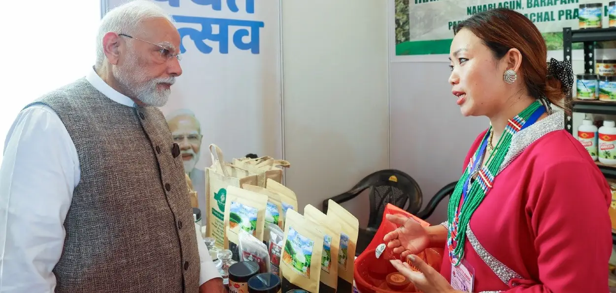 জিএছটি ৰাহি উৎসৱ উপলক্ষে আয়োজিত এখন প্ৰদৰ্শনীত এগৰাকী মহিলাৰ সৈতে প্ৰধানমন্ত্ৰী মোদী  
