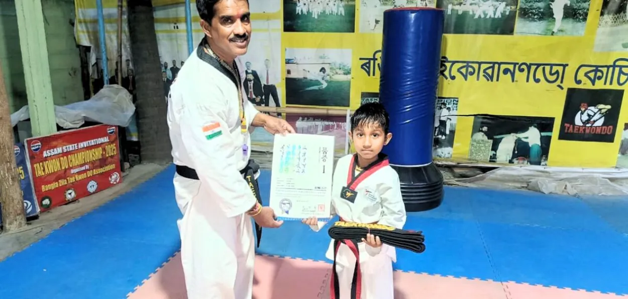 উমৰ ফাৰুকক ব্লেক বেল্ট প্ৰদান কৰাৰ মুহূৰ্তত প্ৰশিক্ষক সুজল গুহ